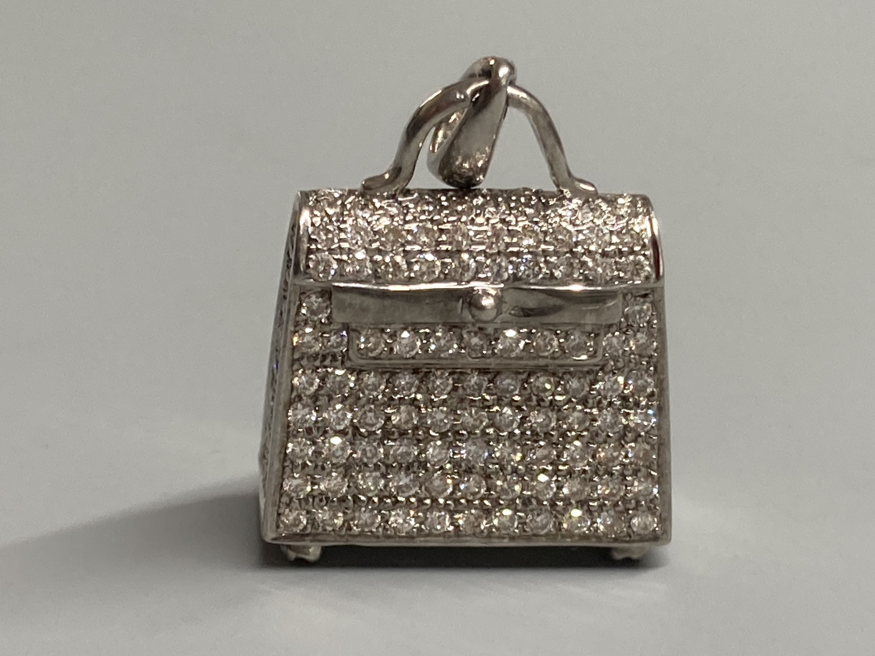 A modern 18k 750 white metal and diamond encrusted handbag charm, with diamond set bale and four diamond set feet, 22mm, gross 9.7 grams